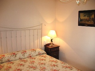 Ein Schlafzimmer hat ein Doppelbett und einen groen Einbauschrank